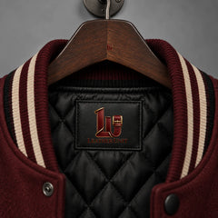 Close-up of Raven Manor varsity jacket black quilted lining and burgundy black cream striped rib collar