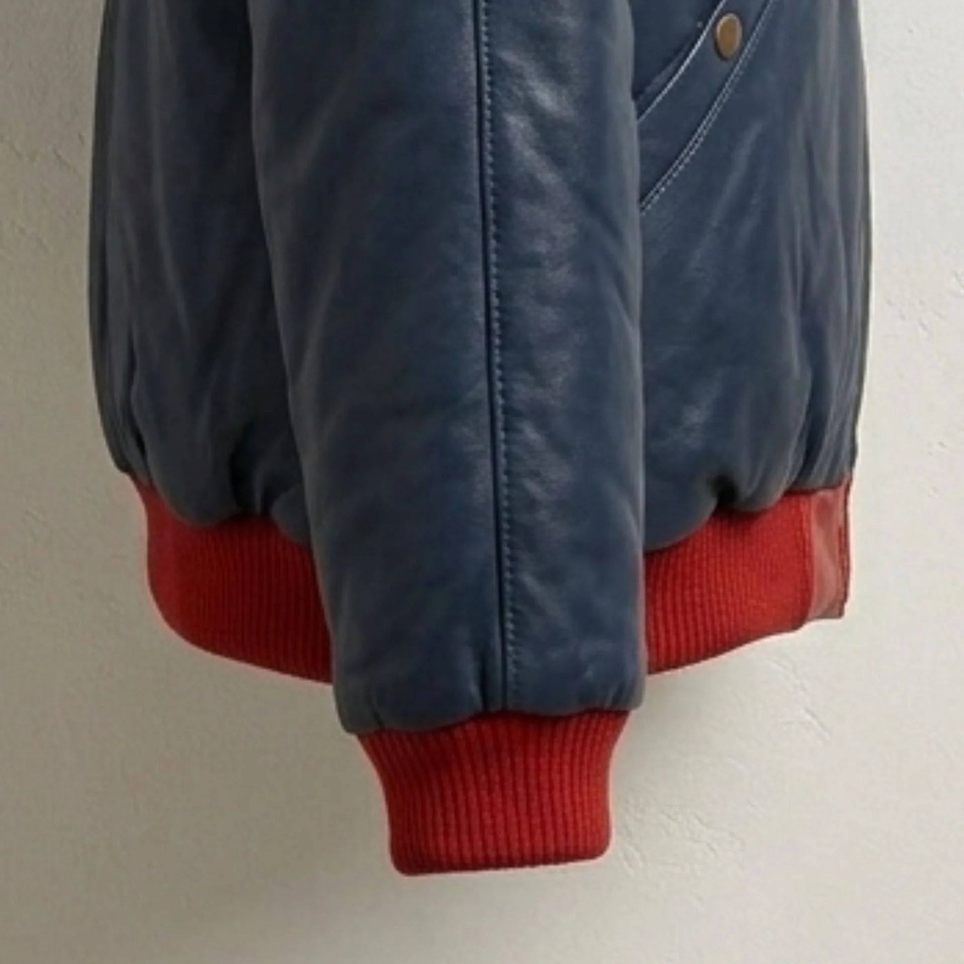 Detailed view of red ribbed cuff and premium leather texture
