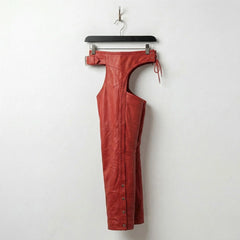 Opposite side view of red leather biker chaps hanging on hanger