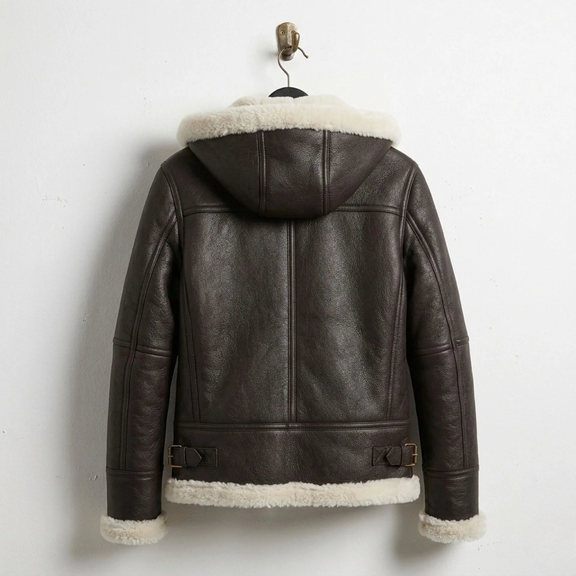 Back view of women’s brown hooded shearling aviator leather jacket with hem buckles