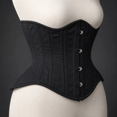 Side profile of black underbust corset showing structured waist shaping, curved upper edge and flared lower panels