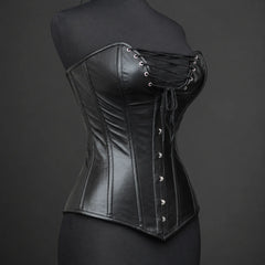Three-quarter product angle showing smooth black leather, plunge bust lacing, curved panel seams and front busk detail.
