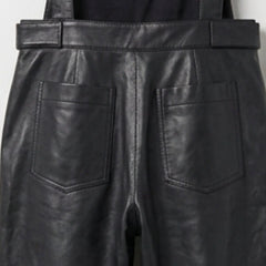Close up of back patch pockets on black leather overalls
