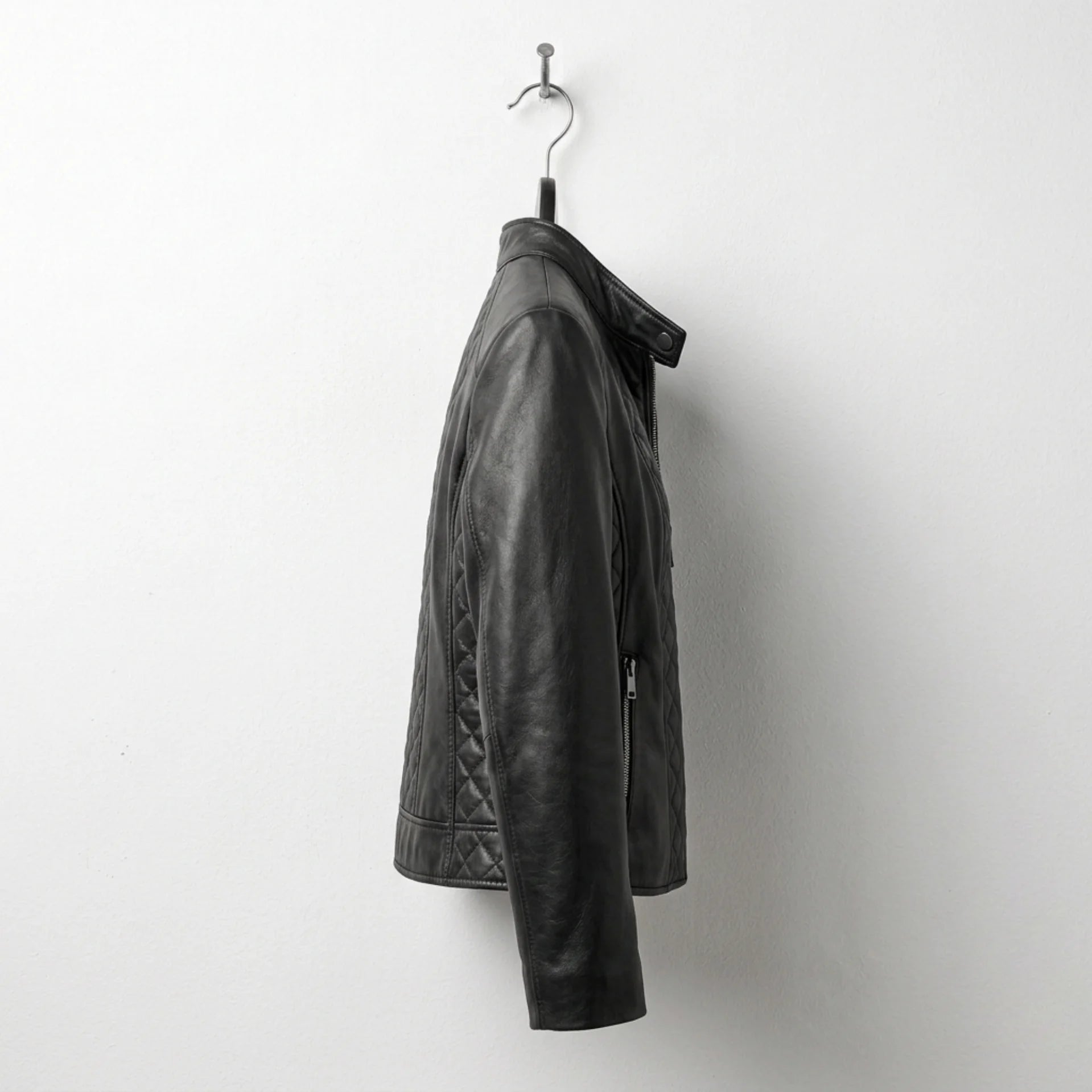 Side profile of women’s black quilted leather moto jacket