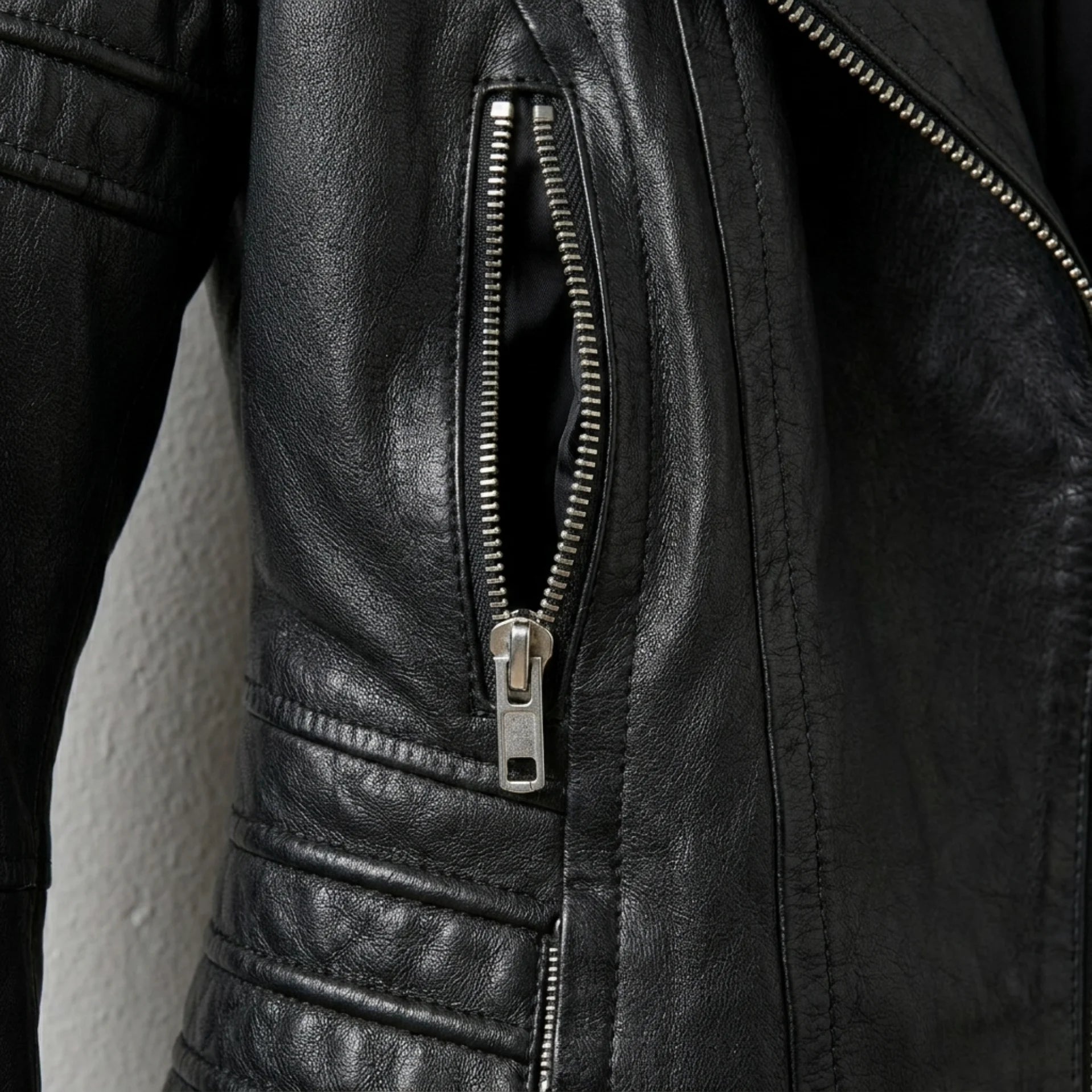 Zipper pocket and quilted waist detail on women’s black moto jacket