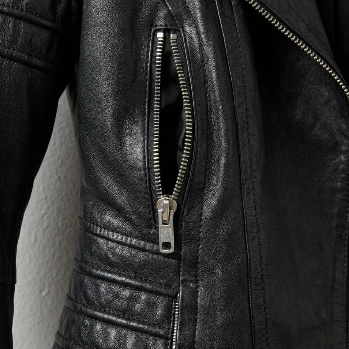 Zipper pocket and quilted waist detail on women’s black moto jacket