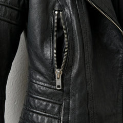 Zipper pocket and quilted waist detail on women’s black moto jacket