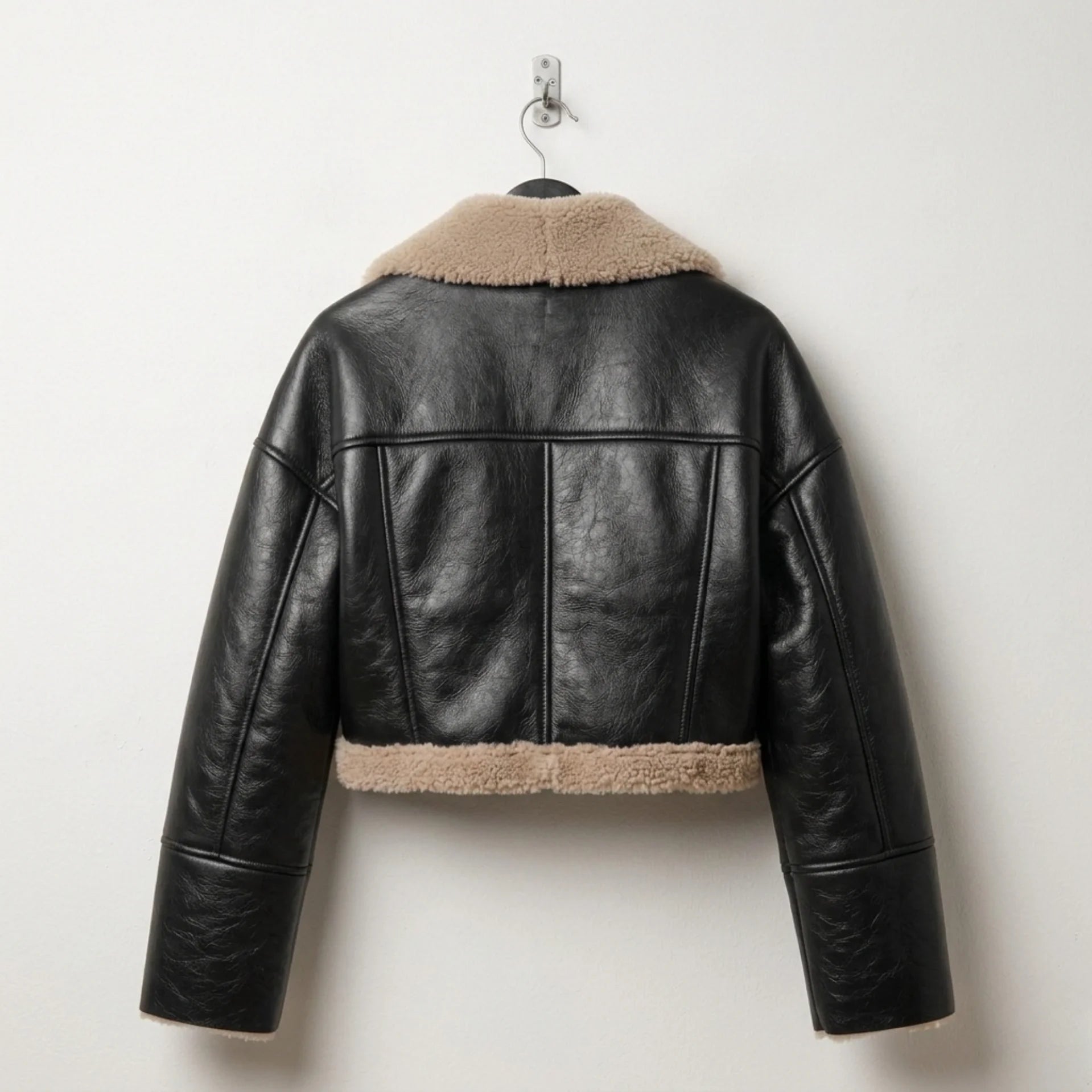 Back view of women’s black cropped shearling leather jacket