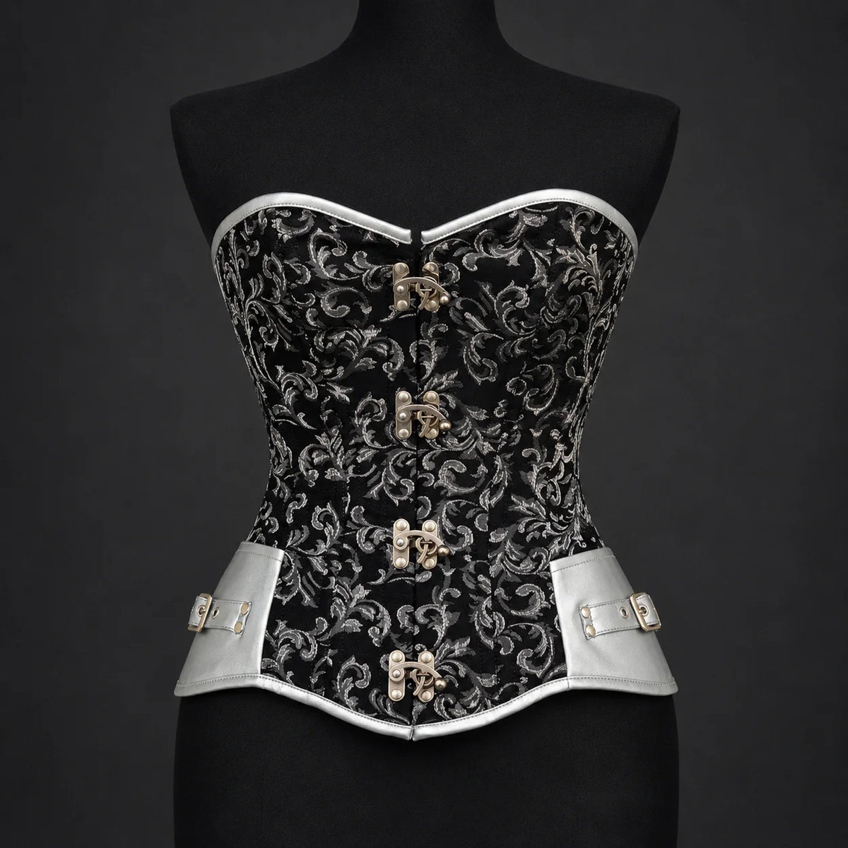 Front studio view of black silver overbust corset showing floral pattern, silver trim and four decorative clasps