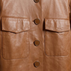 Close-up of chest flap pockets and button front on women’s collarless leather jacket