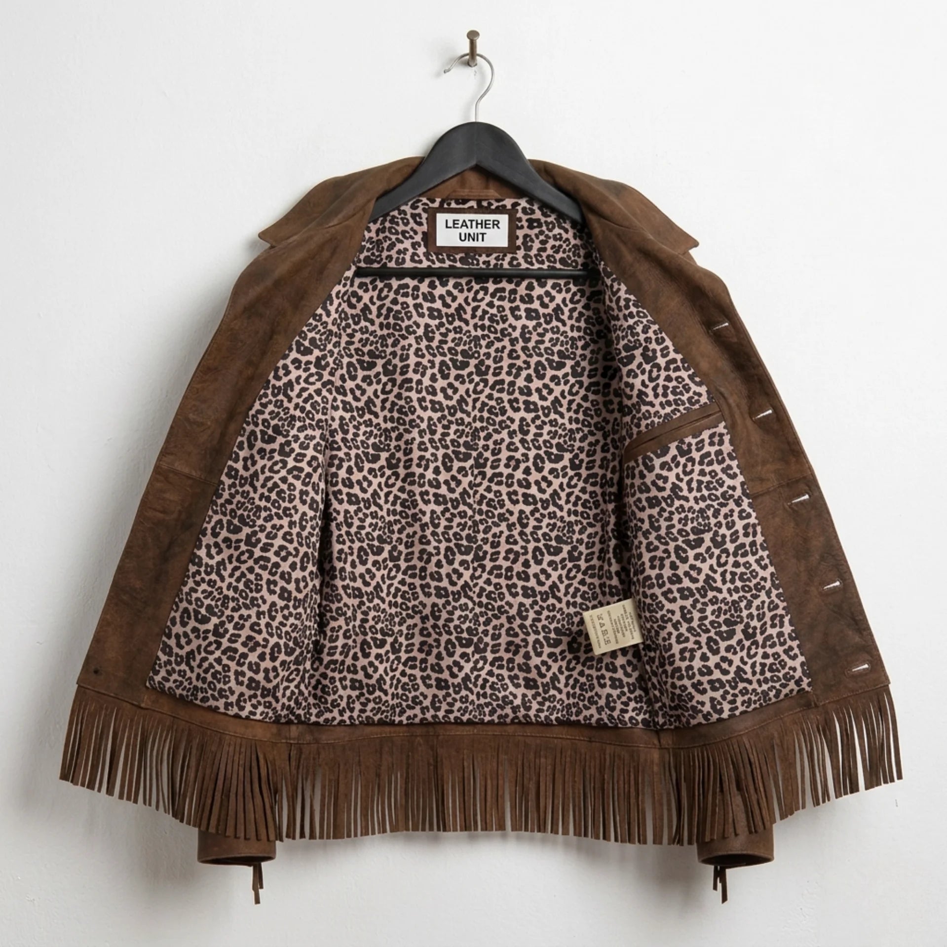 Inside view showing leopard-print lining of women’s brown fringe leather jacket