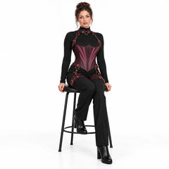 Seated model wearing plum leather corset harness with a matching O-ring collar, contrasting front panels and thigh straps.