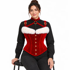 Seated woman wearing Noel Shawl red velvet corset with gold-tone front fastenings, neck harness and fluffy white trim.