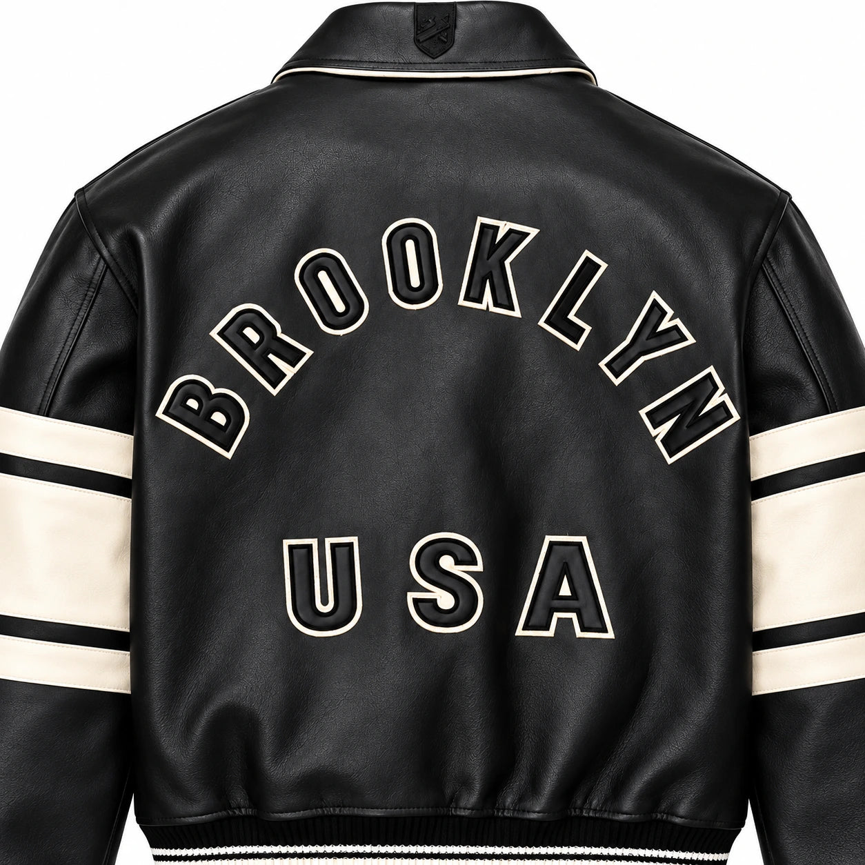 Close-up rear view of Avirex Brooklyn USA black leather jacket showing appliqué-style lettering and textured leather finish