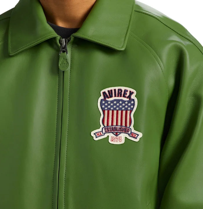 Close-up of Avirex green Icon leather jacket showing fold-down collar, front zipper and Established 1975 shield patch