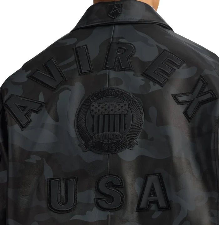 Close-up rear view of Avirex camo leather jacket showing tonal AVIREX lettering, monochrome crest and USA appliqué
