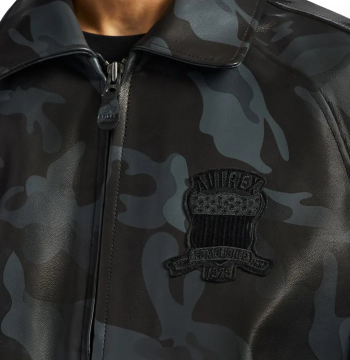 Close-up of grey black camouflage Avirex leather jacket showing tonal heritage chest patch, collar and front zipper