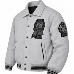 Three-quarter front view of Avirex men’s grey Twin Dragon leather jacket with snap buttons, graphic patches and striped rib trims