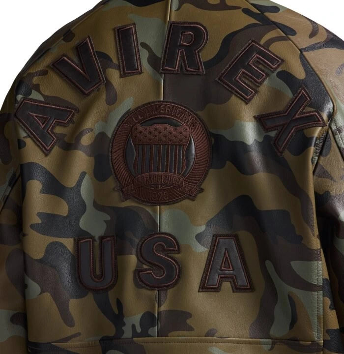 Close-up back detail of Avirex olive camo leather bomber showing AVIREX lettering, heritage crest and USA appliqué