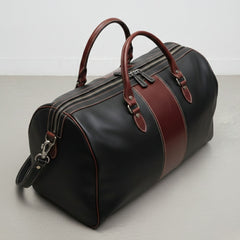 angled top view black brown leather duffle showing double zipper closure.