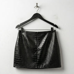 Back view of black crocodile embossed mini leather skirt on hanger