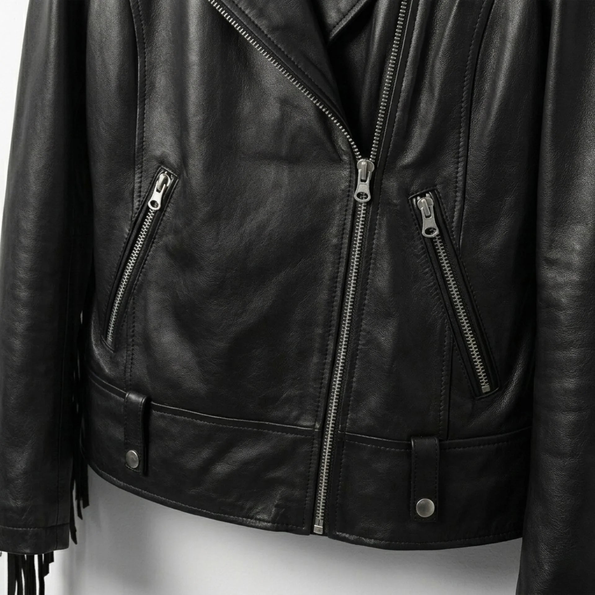 Front zipper and pocket detail on black fringe leather jacket for women