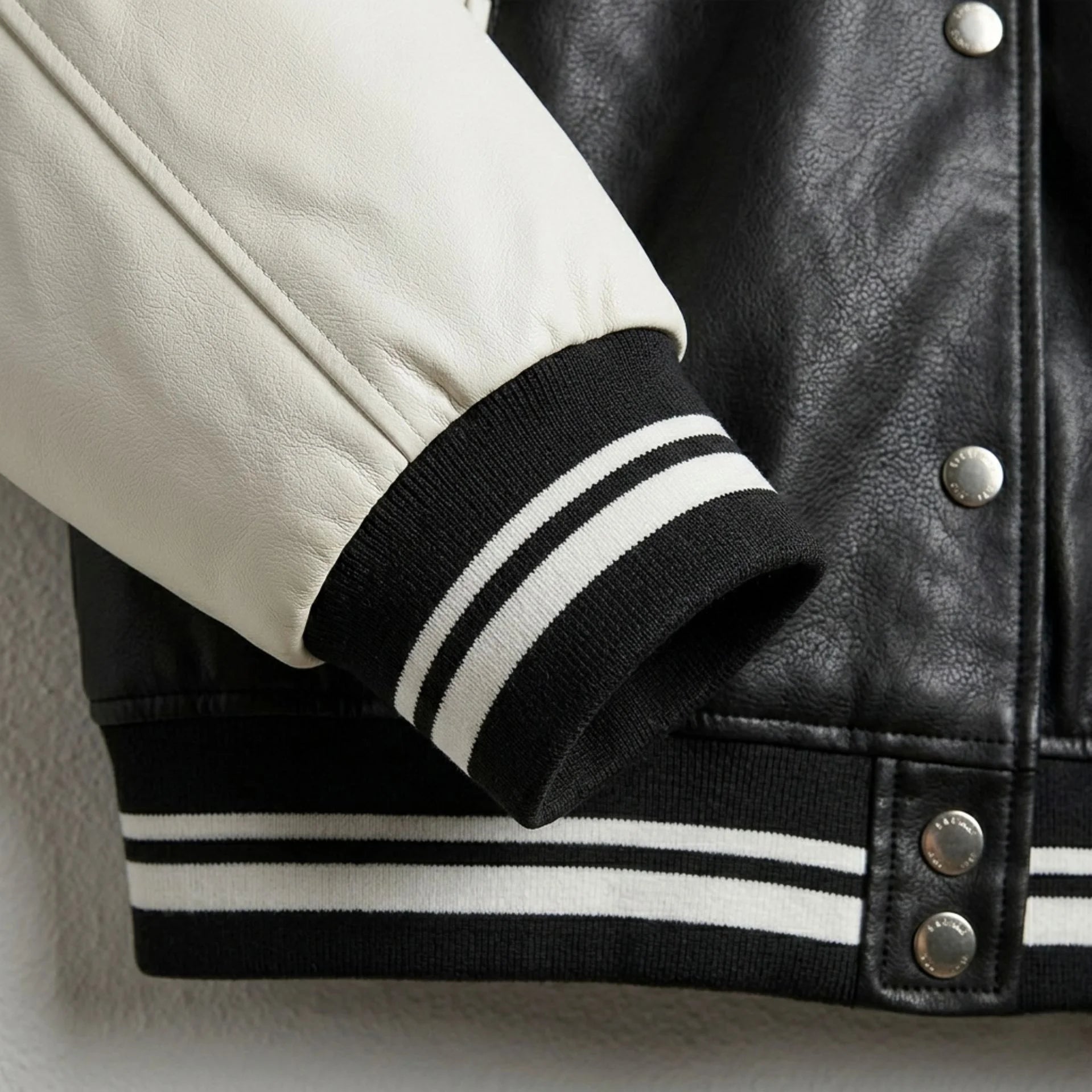 Striped rib knit cuff and white leather sleeve on varsity bomber jacket