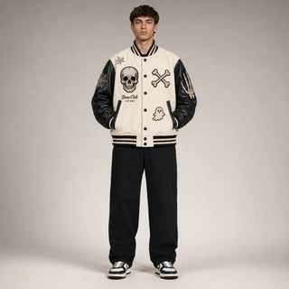 Front studio view of Bone Club skull varsity jacket showing bone-white body, black sleeves and embroidered Halloween patches