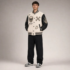 Three-quarter view of bone-white Halloween varsity jacket with black faux leather sleeves and skull patch details