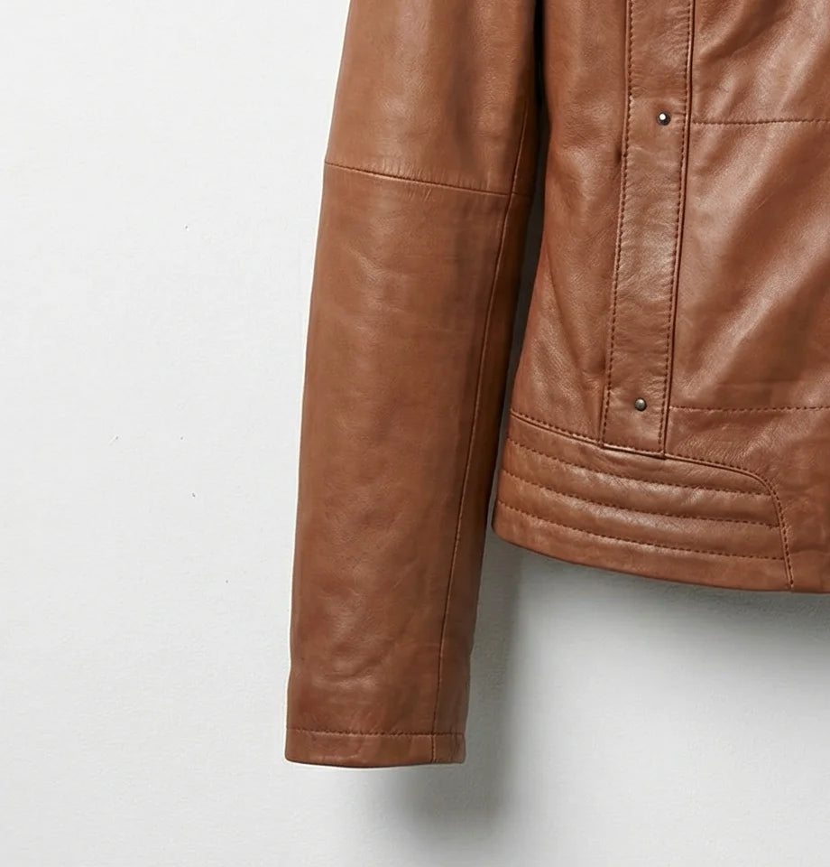 Close up of brown leather bomber jacket sleeve and quilted hem detail