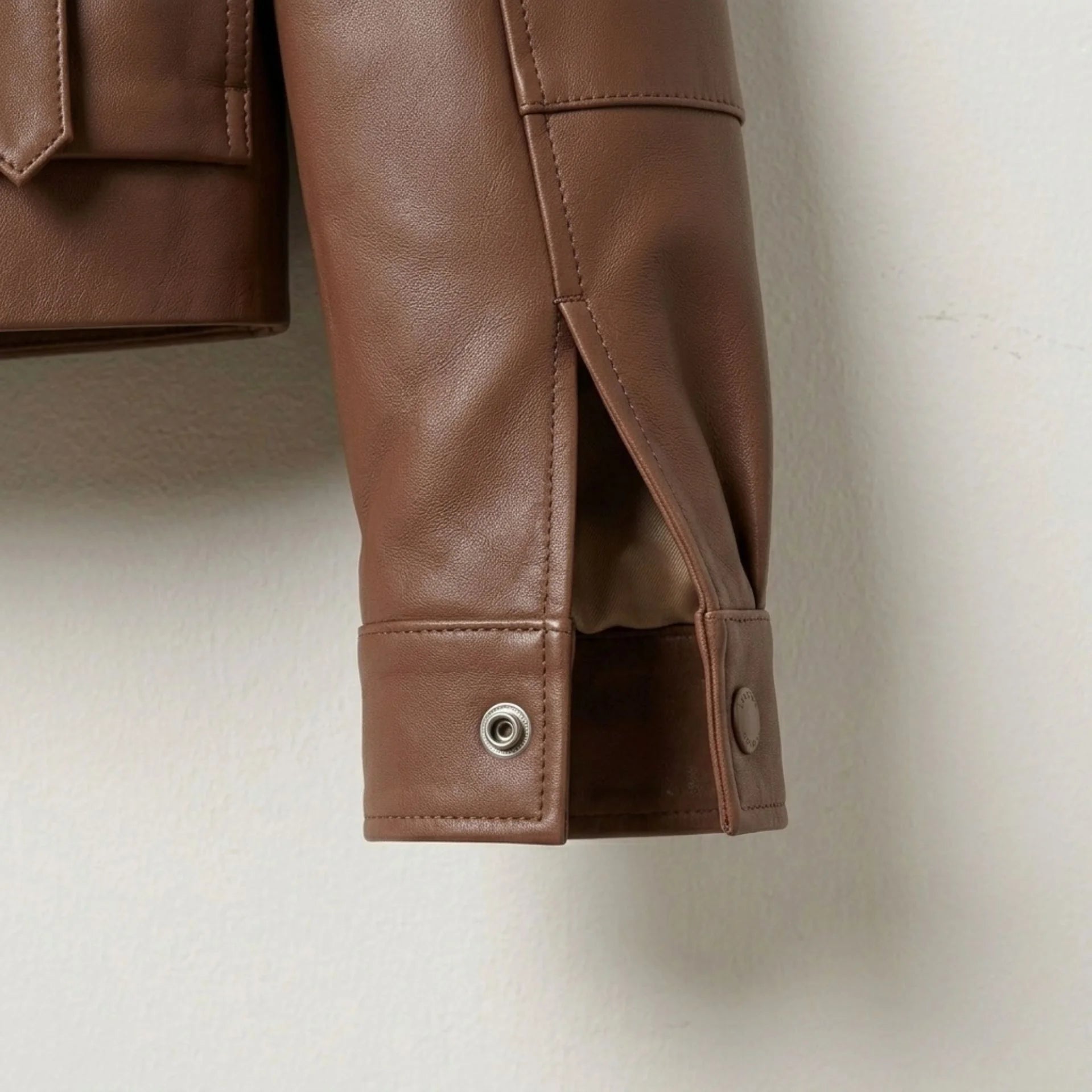 Snap cuff and sleeve vent detail on womens brown leather bomber jacket