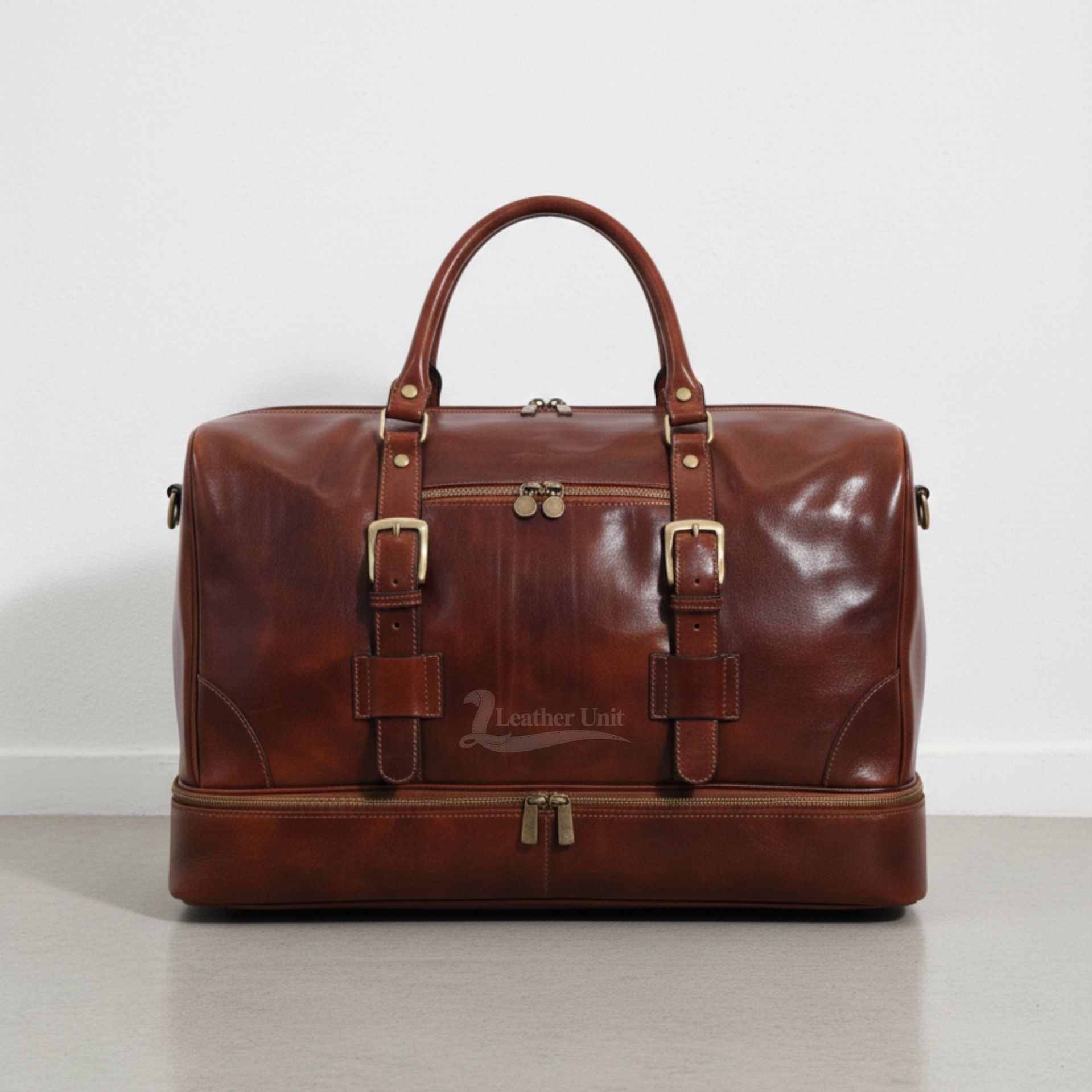 front view brown leather drop bottom duffle bag with buckles and front zip pocket by Leather Unit.