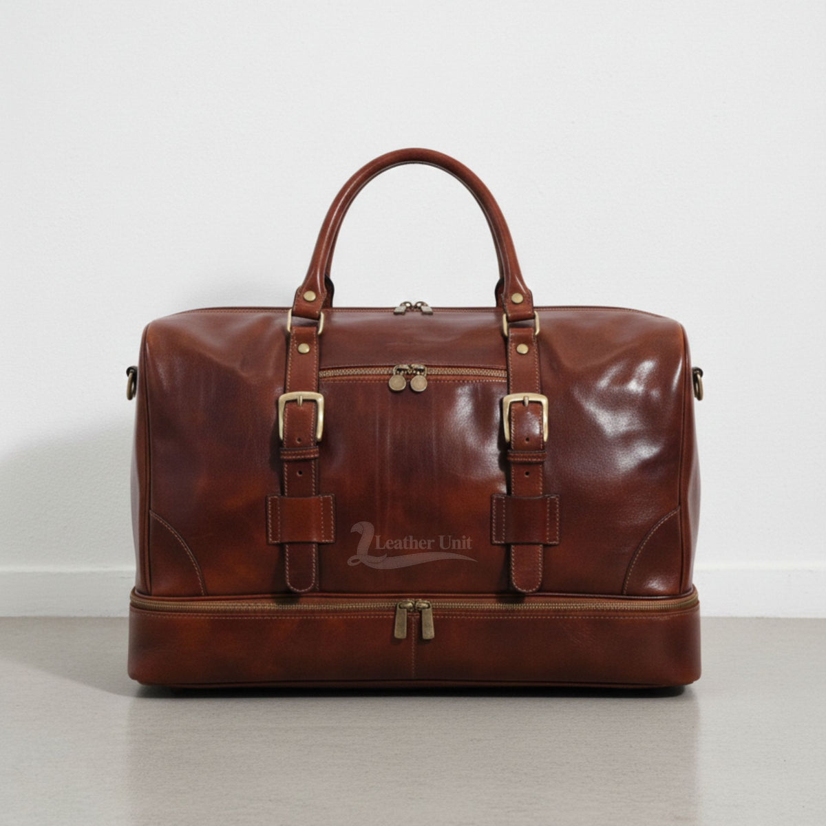front view brown leather drop bottom duffle bag with buckles and front zip pocket by Leather Unit.