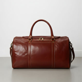 brown leather duffle bag with detachable shoulder strap and double handles.