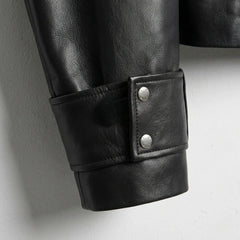 Close up of wide cuff strap with snap buttons on black leather jacket