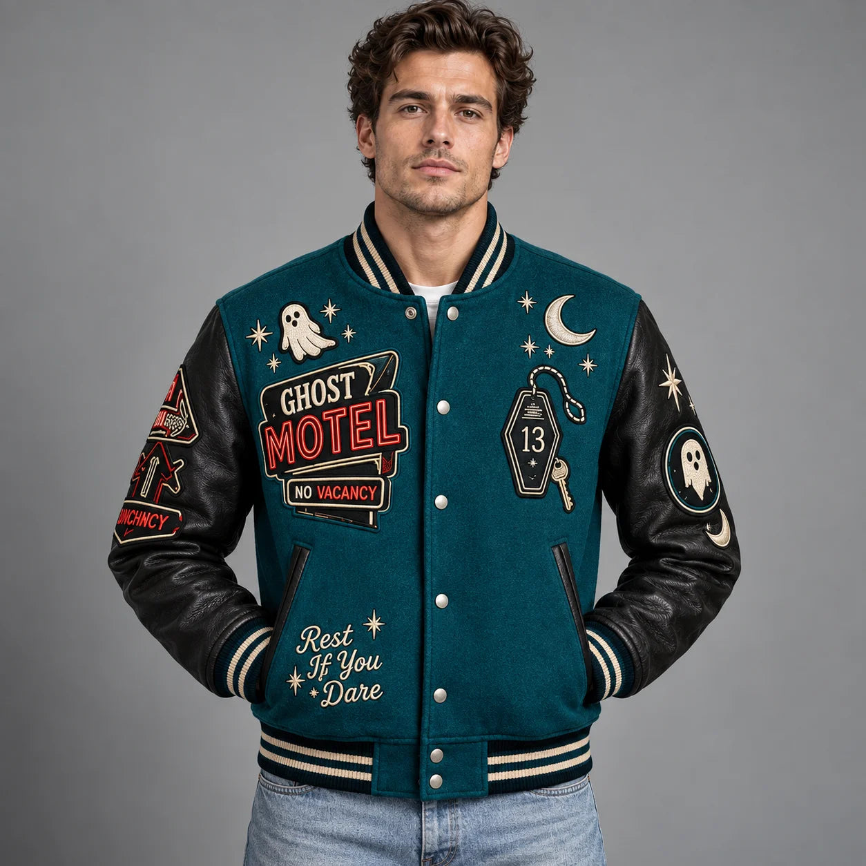 Front studio view of teal Ghost Motel varsity jacket with No Vacancy sign, room 13 key and ghost embroidery