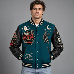 Front studio view of teal Ghost Motel varsity jacket with No Vacancy sign, room 13 key and ghost embroidery