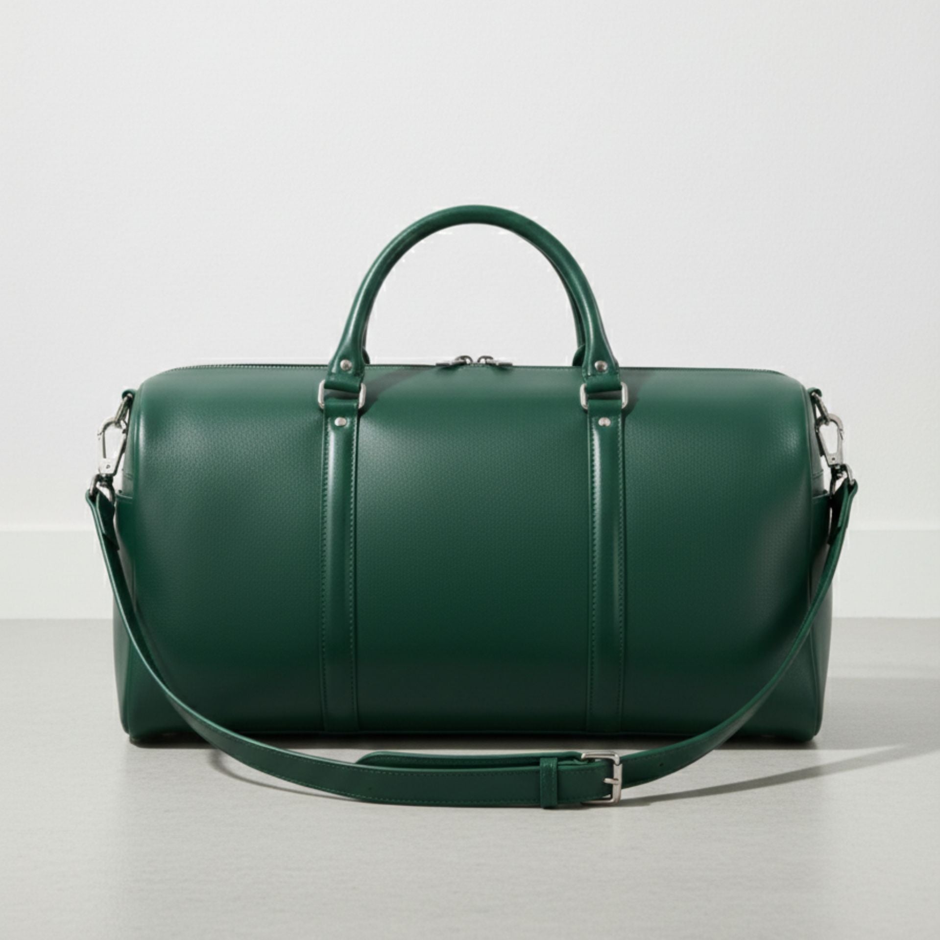 green leather duffle bag with detachable shoulder strap and silver hardware.