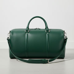 green leather duffle bag with detachable shoulder strap and silver hardware.