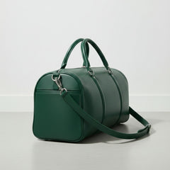 side angle of green leather weekender bag showing exterior slip pocket.