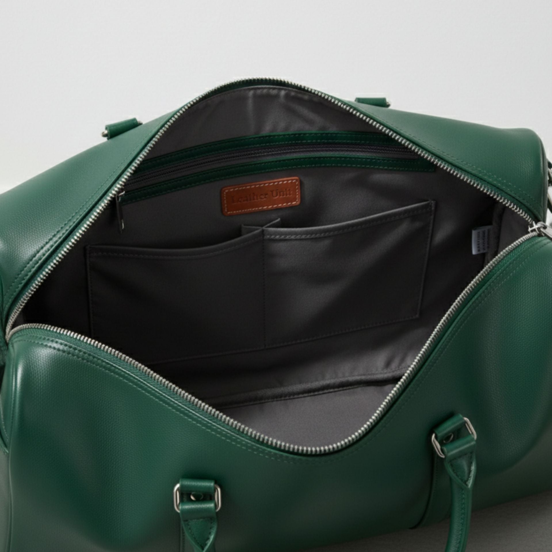 interior of green leather duffle bag with grey lining zip pocket and slip pockets.