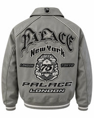 Full back view of grey leather bomber jacket with large graphic emblem, contrast piping and striped ribbed waistband