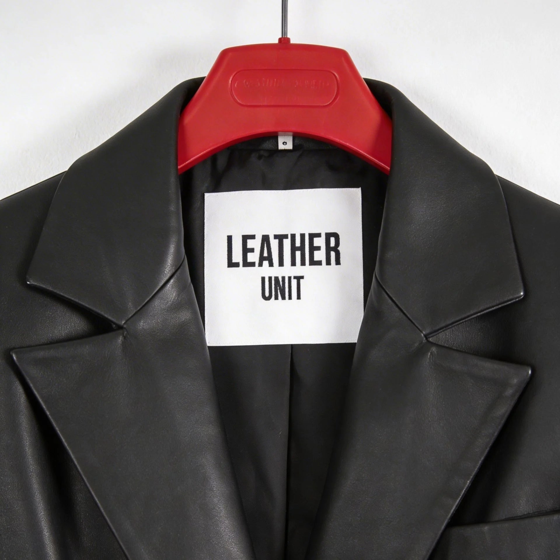 Close up of peak lapels and Leather Unit label on black leather blazer