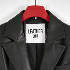 Close up of peak lapels and Leather Unit label on black leather blazer