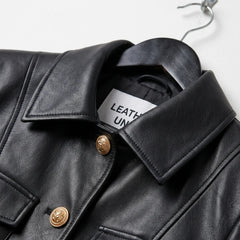 Close-up of collar and gold buttons on black leather military jacket