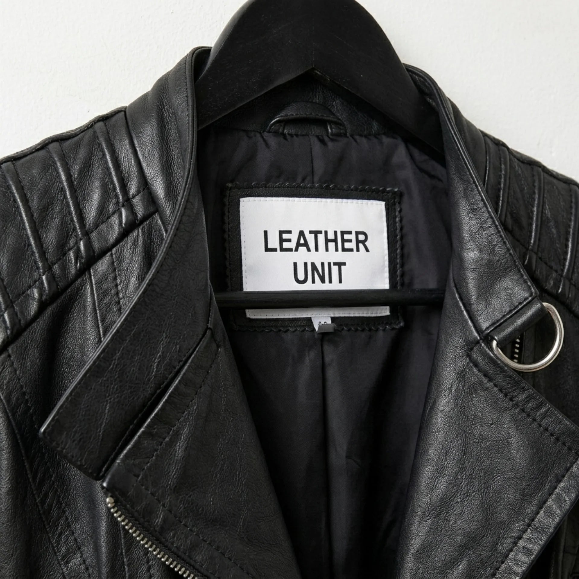 Close-up of lapel collar and Leather Unit label on black moto jacket