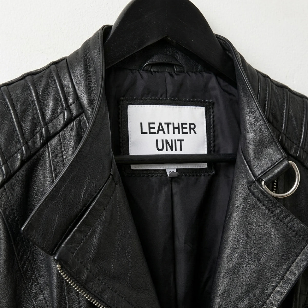 Close-up of lapel collar and Leather Unit label on black moto jacket