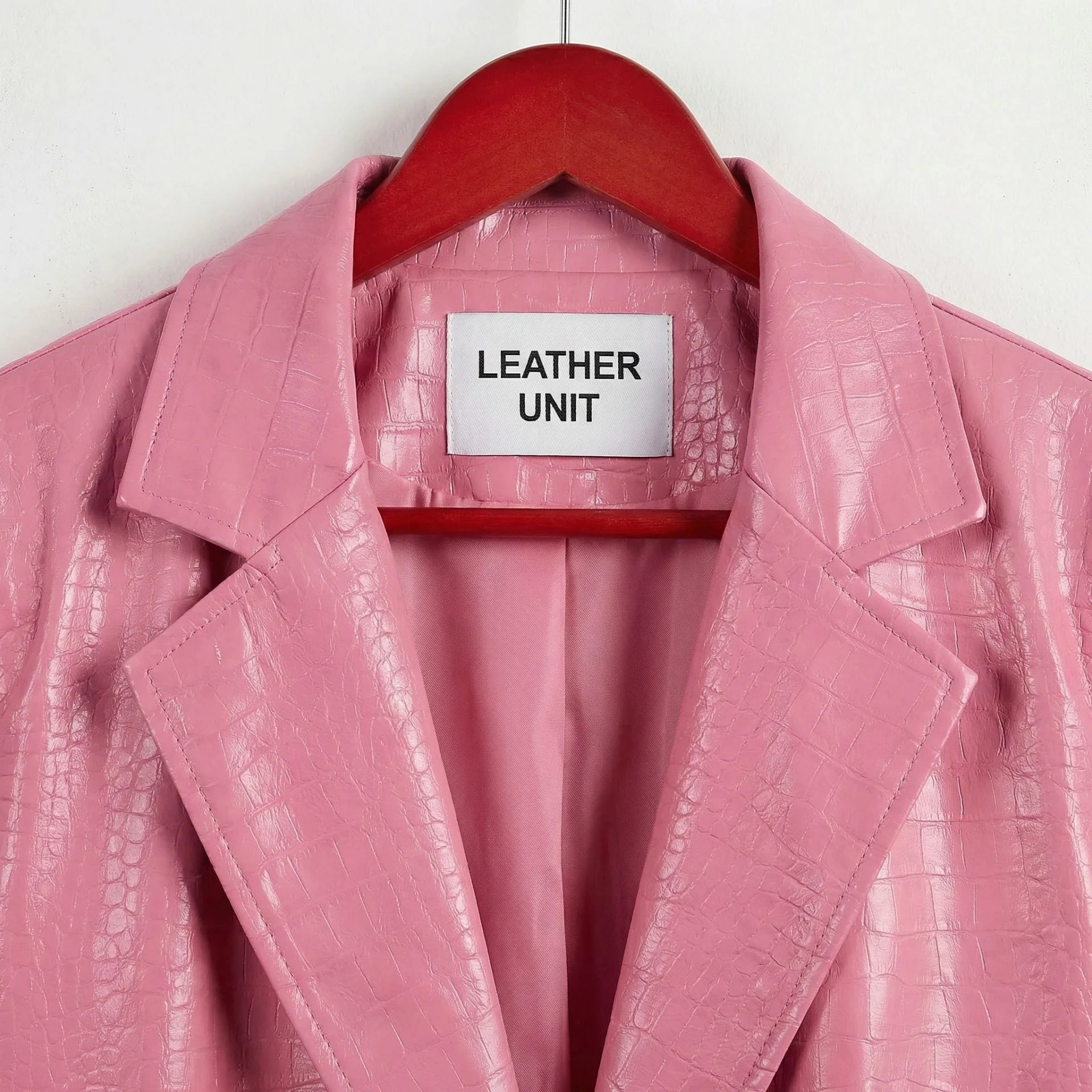Close up of notched lapels and Leather Unit label on pink leather blazer