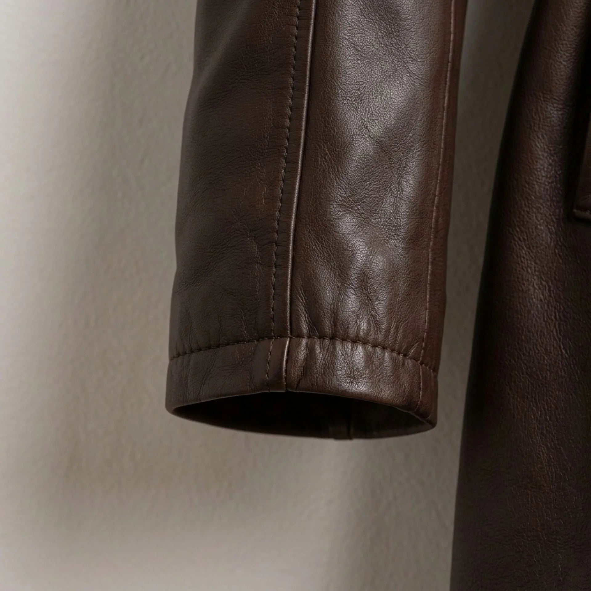 Sleeve cuff detail on women’s brown leather coat with smooth stitching