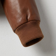 Ribbed cuff detail on women’s brown leather bomber jacket sleeve